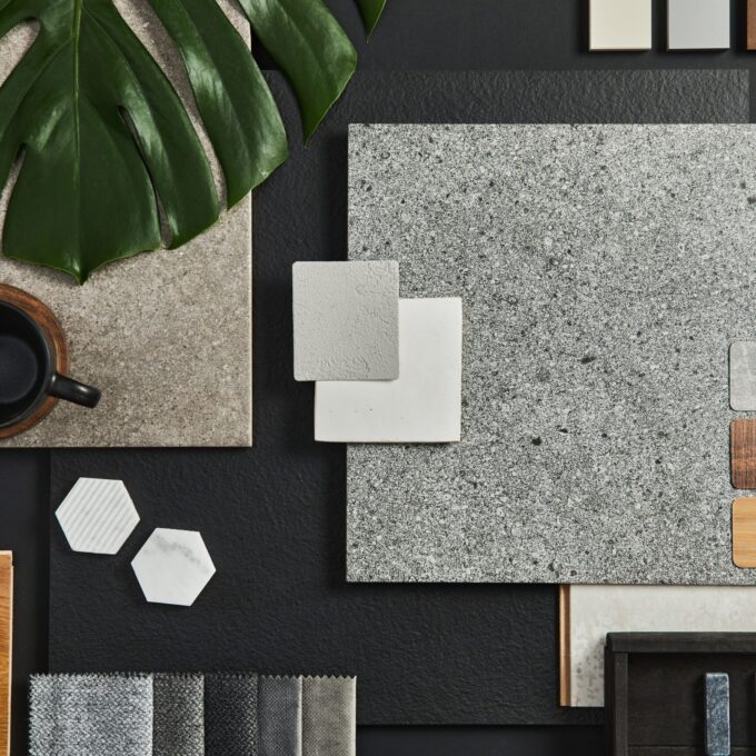 Flat lay composition of creative black architect moodboard with samples of building, textile and natural materials and personal accessories. Top view, black background, template.